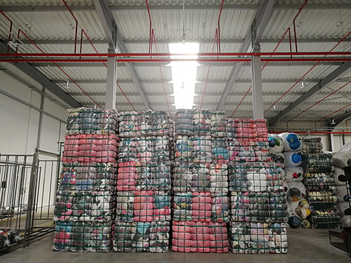 Vestiti riciclati pronti per la partenza nel magazzino Humanita